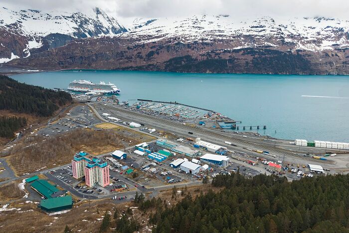 An aerial view of a harbor with a cruise ship and buildings, showcasing curious facts about the location.