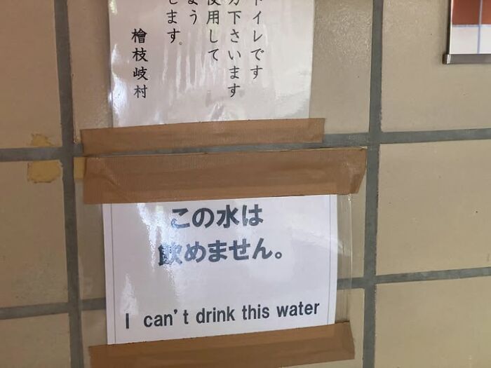 A taped sign in Japan on a tiled wall, displaying the hilarious example of getting lost in translation: I can't drink this water.
