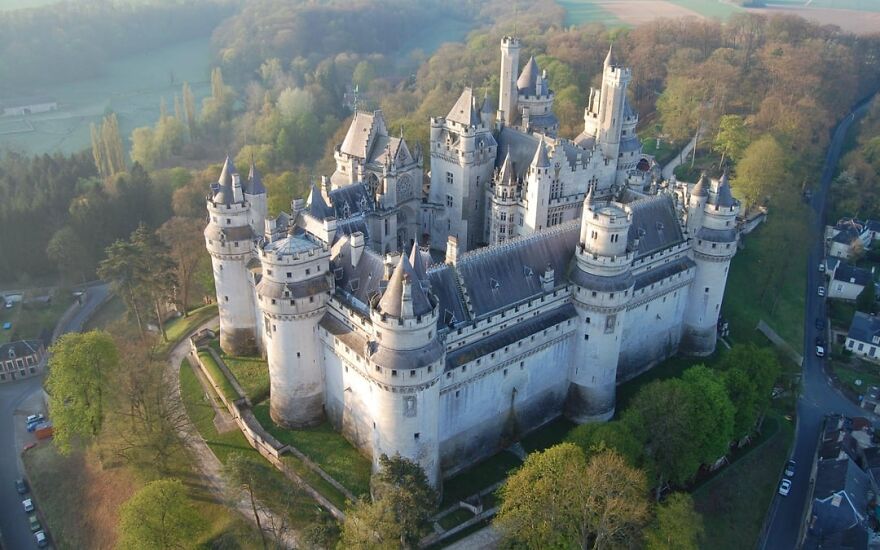 Pierrefonds Castle, a beautiful and interesting medieval fortress with multiple towers, surrounded by trees.