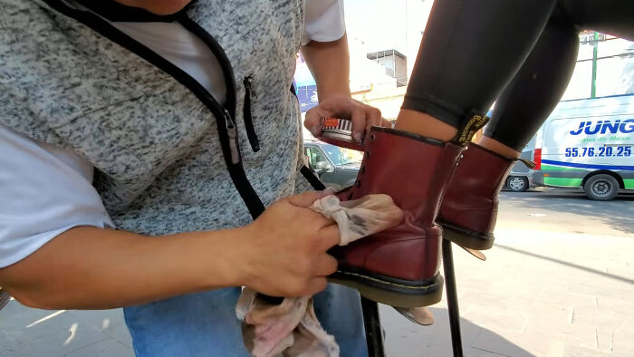 A person shining a red boot, a mundane scene that could hide an internet's creepy unsolved mystery.