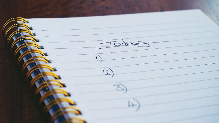 A spiral notebook with Today written and a numbered list, symbolizing the evaluation of dating scenarios with red, green, beige flags.