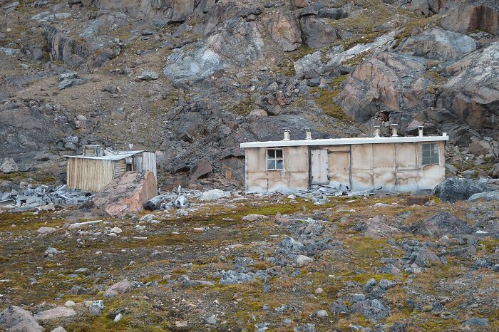 A remote, dilapidated building surrounded by rocks and sparse vegetation, offering a glimpse into history facts.