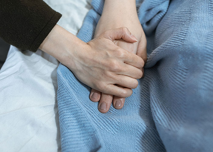 Two people holding hands, representing feelings of loneliness and not looking forward to birthdays.