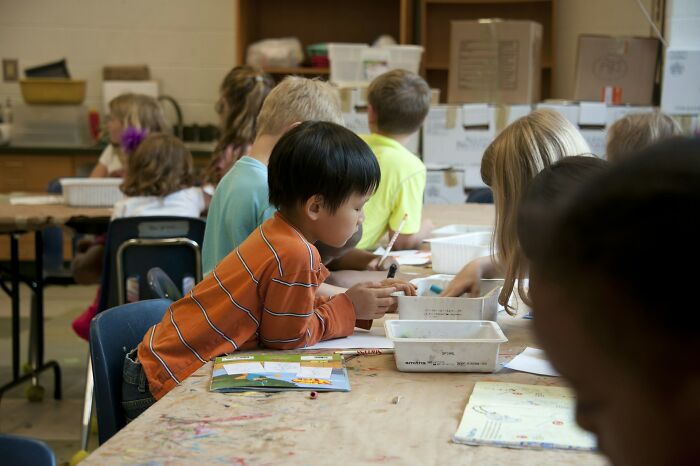 Children of Gen Alpha engaged in classroom activities at school, with many focused on their work. Teachers paint a grim picture.