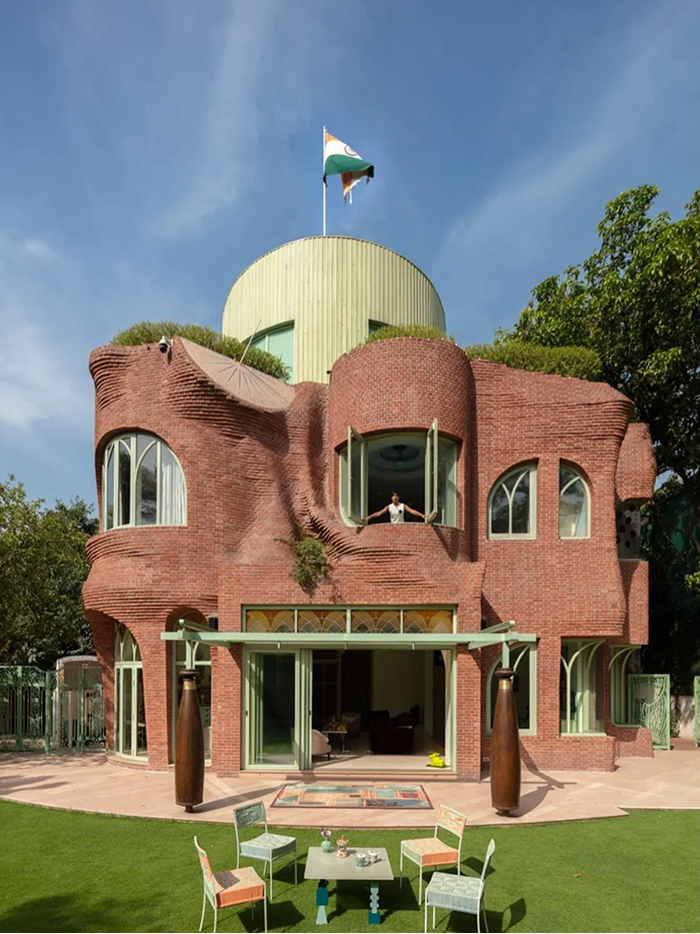 Modern Architecture Designs: A unique brick house with curvilinear walls and a green roof, displaying amazing design.