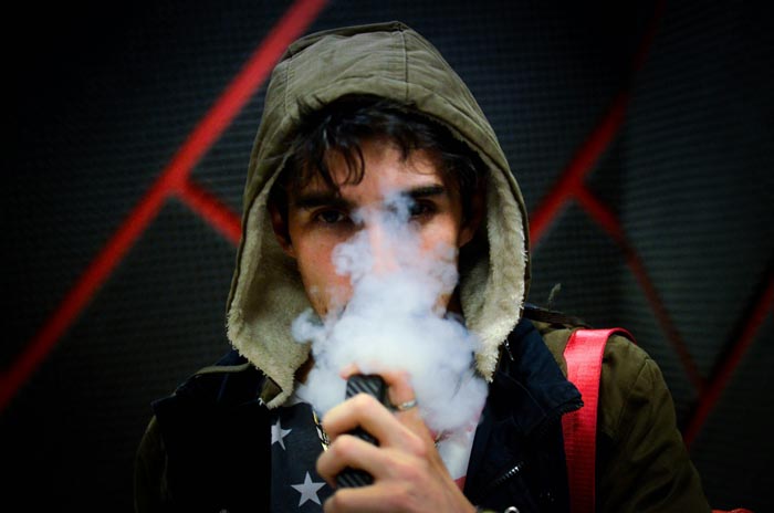 A man vaping, representing a different form of unhygienic habit.