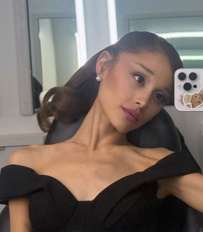 A recent Ariana Grande pic shows the singer looking slender in a black off-the-shoulder top, reflecting fan concern.