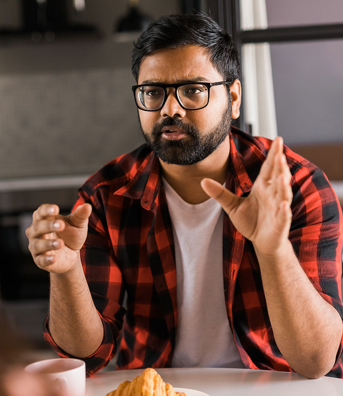 Man thinking about his aunt asking him money, looking stressed at a table with coffee and croissant. Man thinking about his aunt asking him money, looking stressed at a table with coffee and croissant.