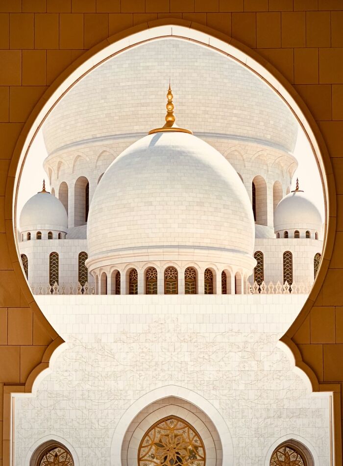 The grand white domes of a mosque framed by an archway, an extraordinary winning iPhone Photography Award photo.