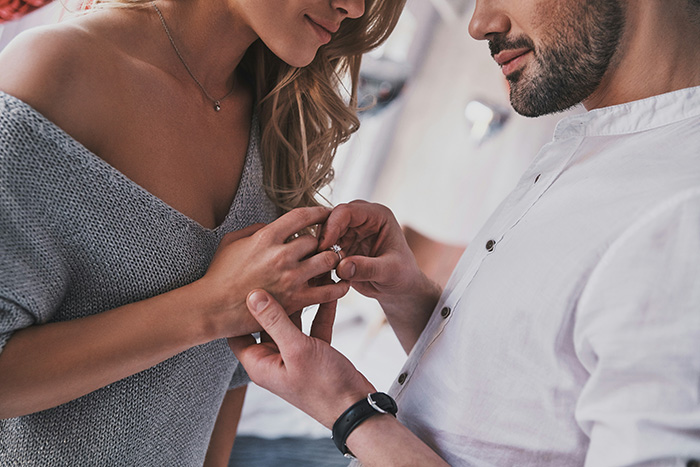 Man proposing with an engagement ring, highlighting a woman rethinking her engagement after a backup plan reveal.