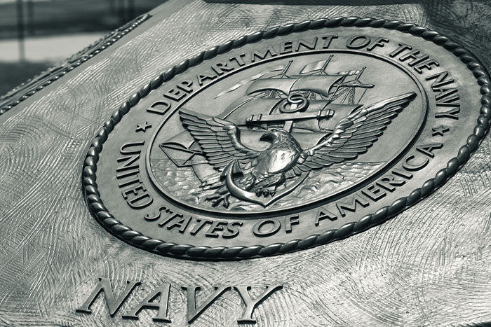 A close-up of a bronze emblem for the US Department of the Navy, a key part of unfortunate names and their origins.
