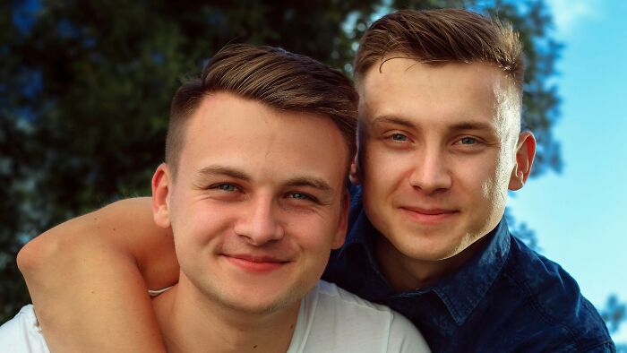 Two happy men smiling and hugging, representing the voice of reason in situations where people overreacted.