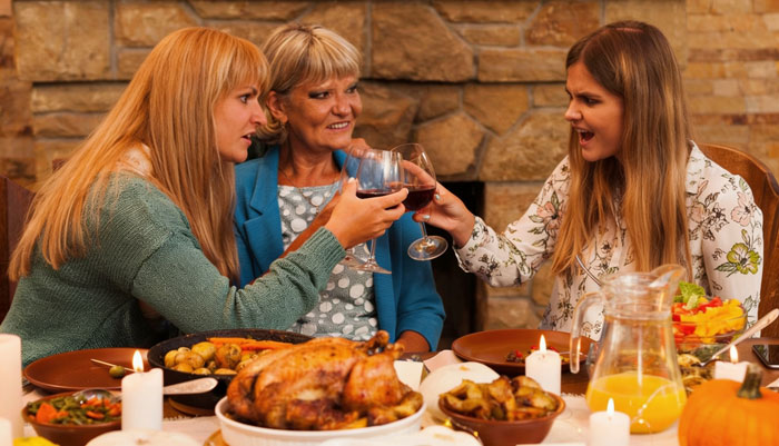 Family enjoying Thanksgiving holiday dish with essential oils at a cozy dinner party. Family enjoying Thanksgiving holiday dish with essential oils at a cozy dinner party.