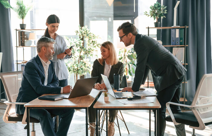A group of diverse workers collaborating in a modern office, perhaps discussing corporate buzzwords.