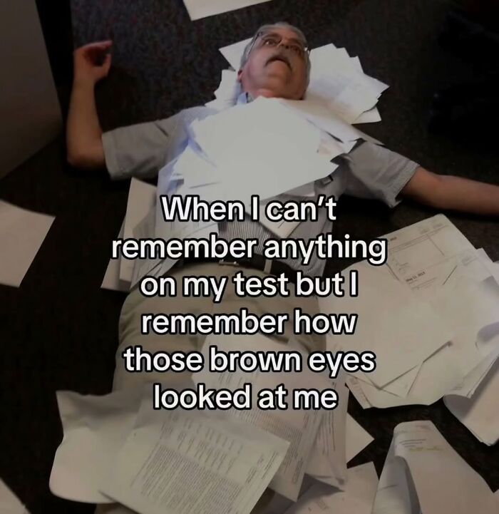 A man lying on the floor surrounded by papers, a relatable meme about forgetting test answers but remembering a crush.