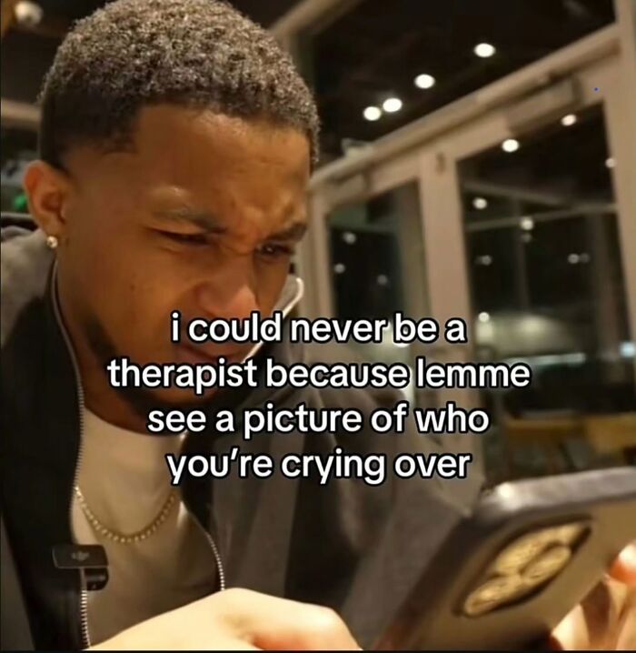 A man looking at his phone with a relatable meme about wanting to see a picture of who someone is crying over.