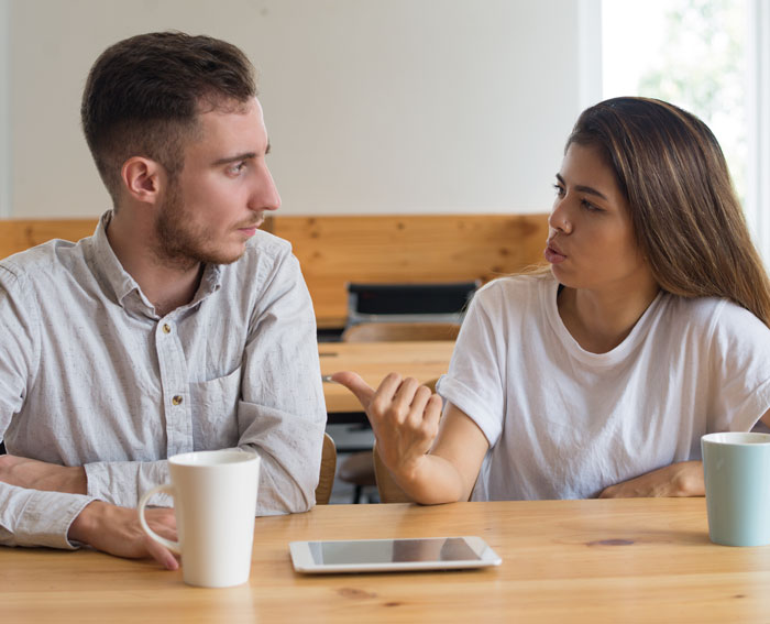 A woman explaining something to a man with a clever comeback, illustrating an article about clever comebacks.