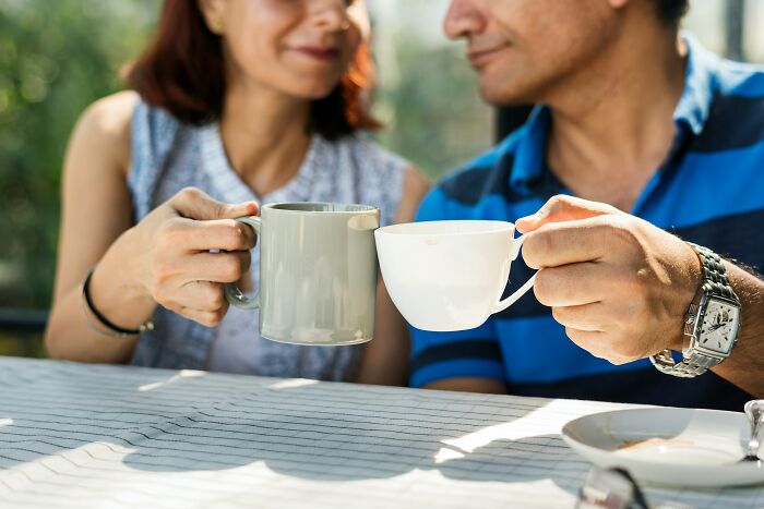 A couple toasting with coffee mugs, representing different perspectives on age-gap relationships.