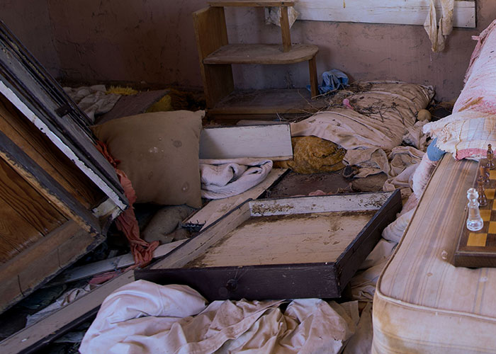 A messy, dirty room in a man's home, suggesting a woman had to leave immediately.