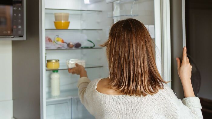 A woman opening a refrigerator, symbolizing a moment of overreaction in a story.