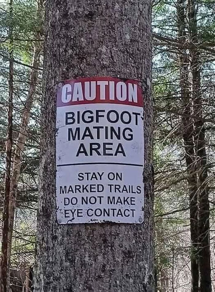 A warning sign on a tree that reads Caution Bigfoot Mating Area, Stay on Marked Trails Do Not Make Eye Contact, a ridiculous post.