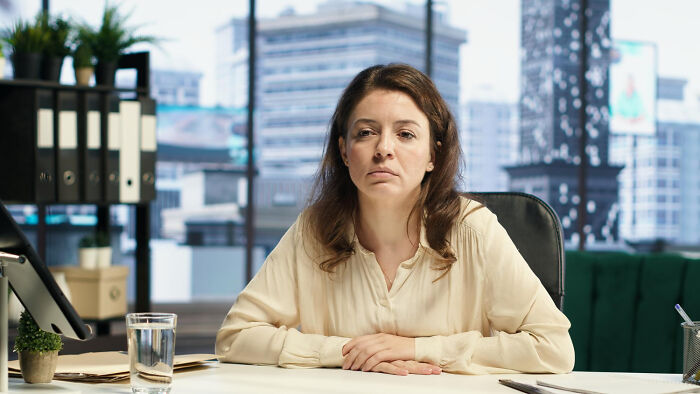 A female worker with a serious expression, reflecting on corporate buzzwords.