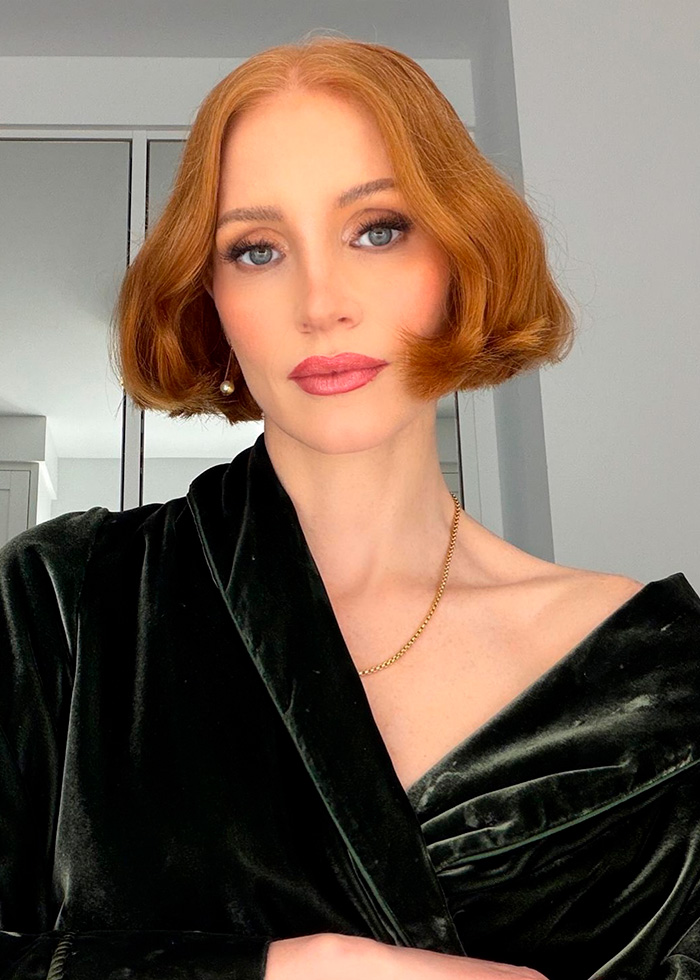 A celebrity with red hair and a dark green velvet top, showcasing wedding fashion, for Taylor Swift's wedding.