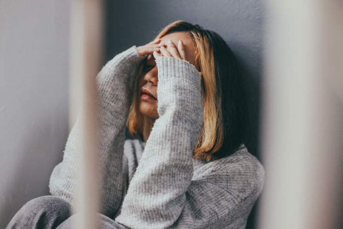 A distraught woman, upset and frustrated, considering contacting a divorce lawyer over her spouse's actions.