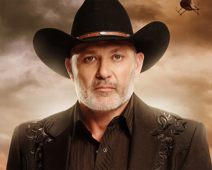 A reality star in a black cowboy hat and jacket, looking serious, part of a list of reality stars who committed serious crimes.