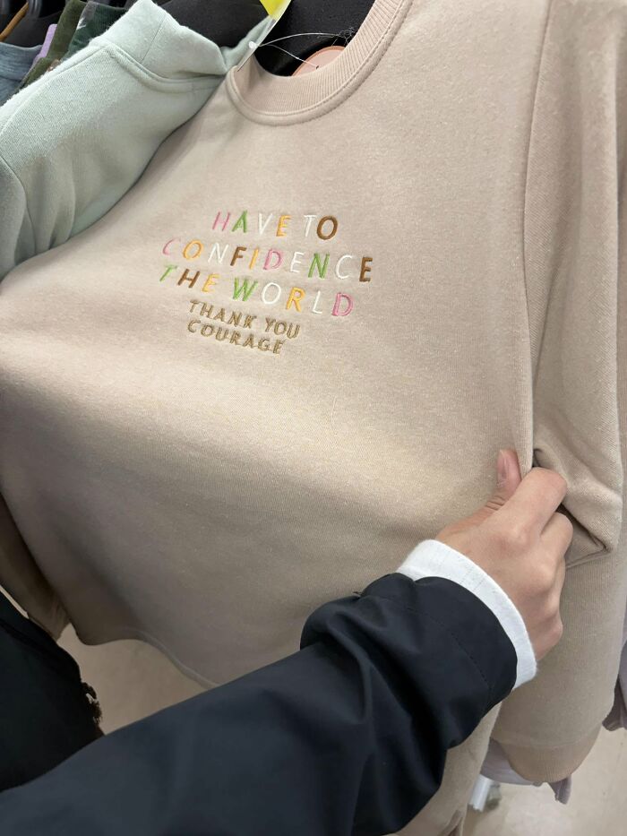 A person holding a sweater with a hilarious example of getting lost in translation, found in Japan.