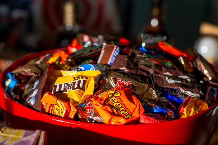 A large red bowl filled with various types of candy, showcasing surprisingly affordable treats.