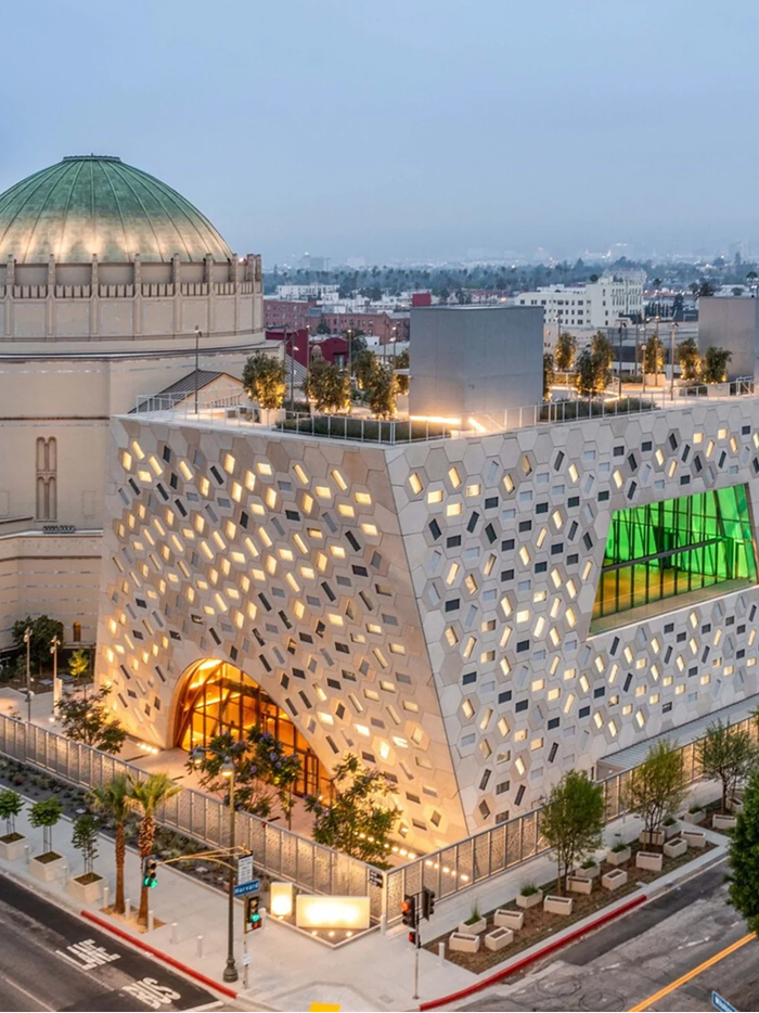Modern architecture design: An innovative building featuring a geometrically patterned facade with varied window openings and a large green-tinted window.