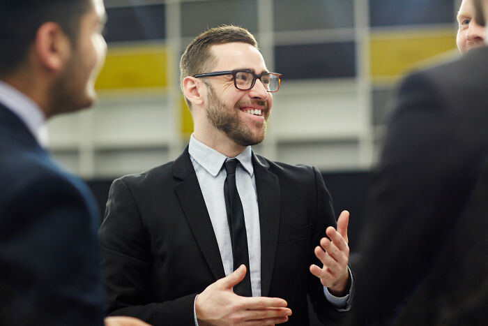 A happy worker smiles and gestures, discussing corporate buzzwords and practices.