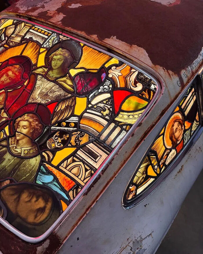 Detailed view of the stained-glass sculpture integrated into the rusted body of a Porsche 911.