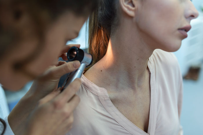 A dermatologist examines a patient's skin, a surprisingly affordable health service people thought were only for the rich.