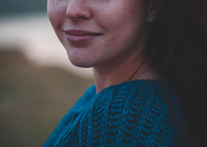 A smiling woman with freckles, pondering if she witnessed reality break.