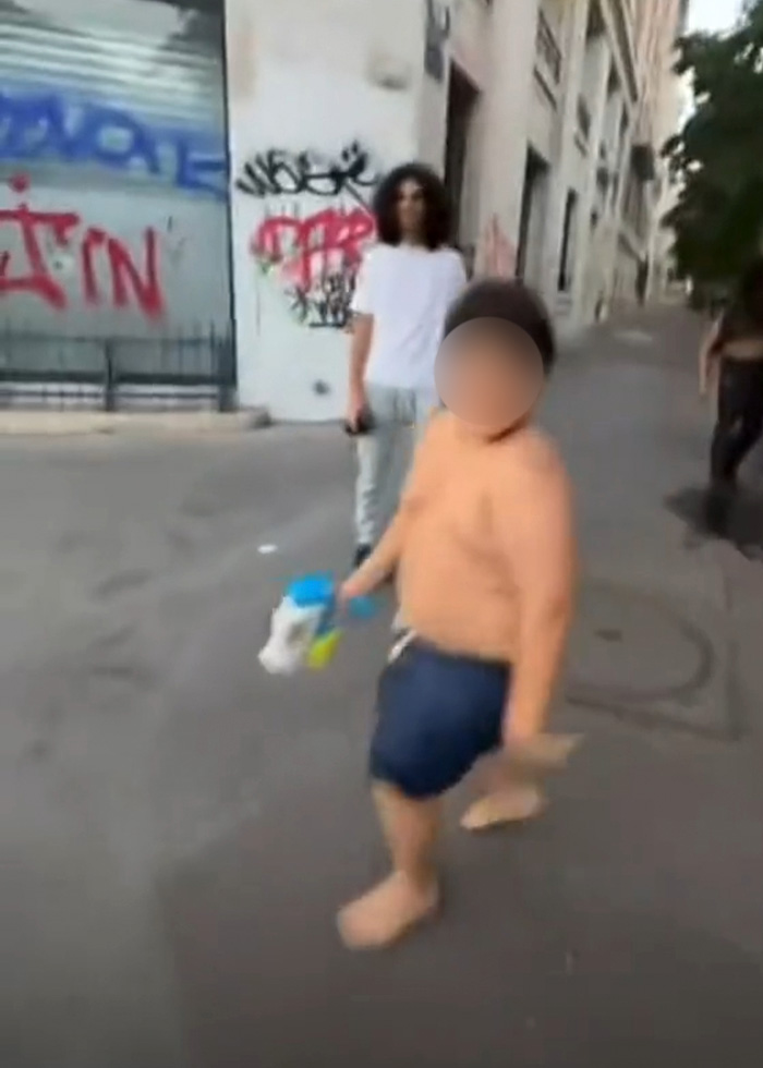 14-year-old boy, with blurred face, holding a water toy on the street. 14-year-old boy, with blurred face, holding a water toy on the street.