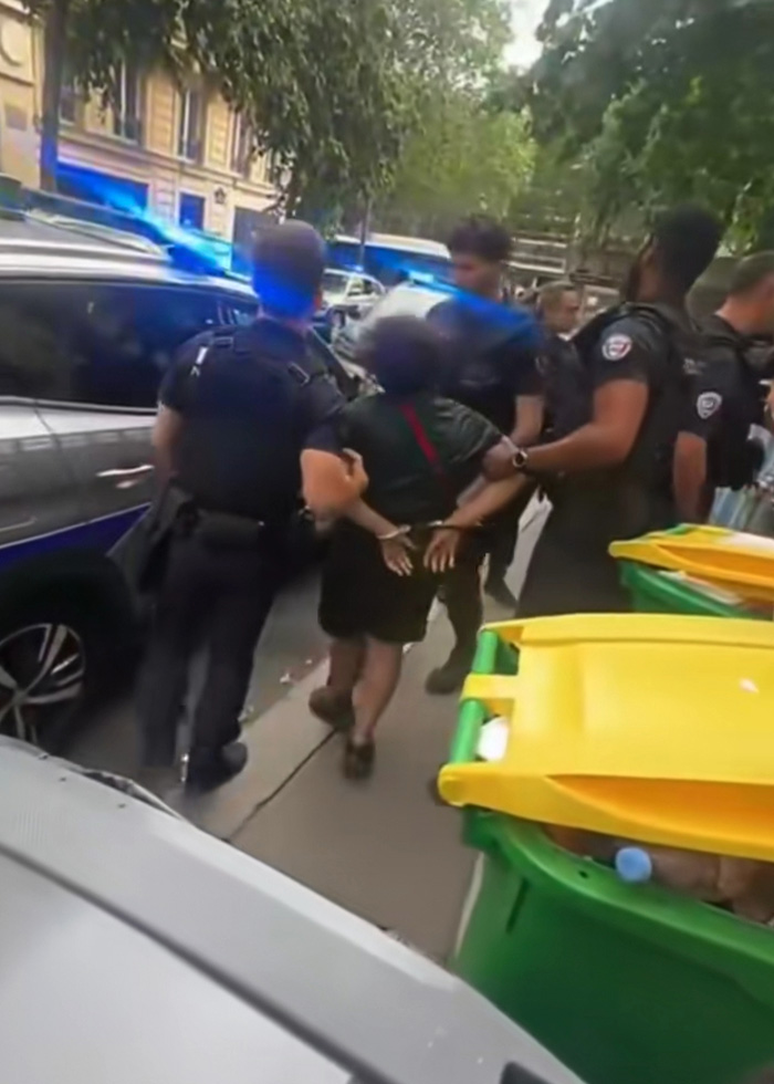 A 14-year-old boy is handcuffed by police officers next to a police car in a controversial case. A 14-year-old boy is handcuffed by police officers next to a police car in a controversial case.