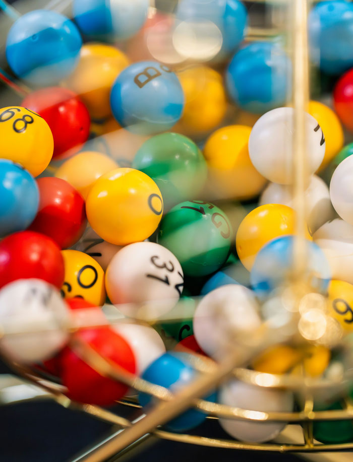 Colorful lottery balls in a spinning cage, representing the randomness of life and clever comebacks.