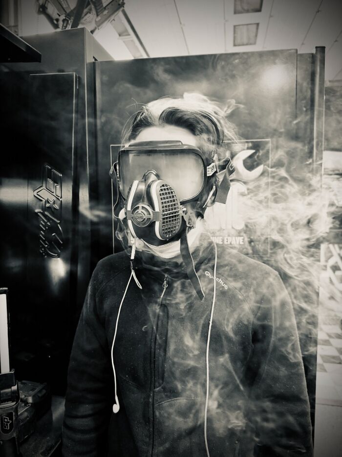 Black and white iPhone Photography Award winning photo of a person in a gas mask surrounded by smoke.