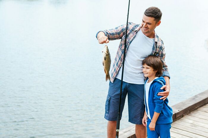 A father and son fishing, holding up a fish, reflecting questions kids asked parents.