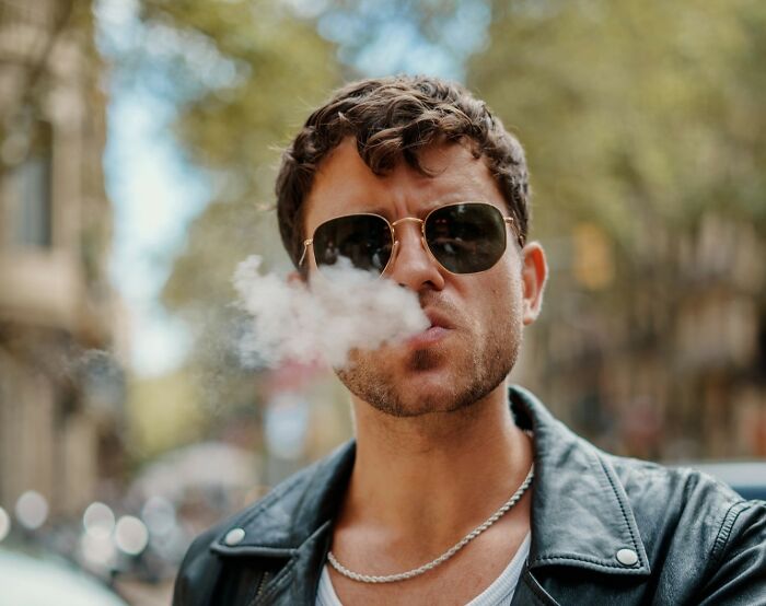 Man in sunglasses and leather jacket exhales smoke, representing a product that swapped audiences.