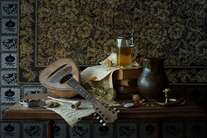 Still life color photo with a mandolin, books, and a tankard of beer, remarkably capturing the world.