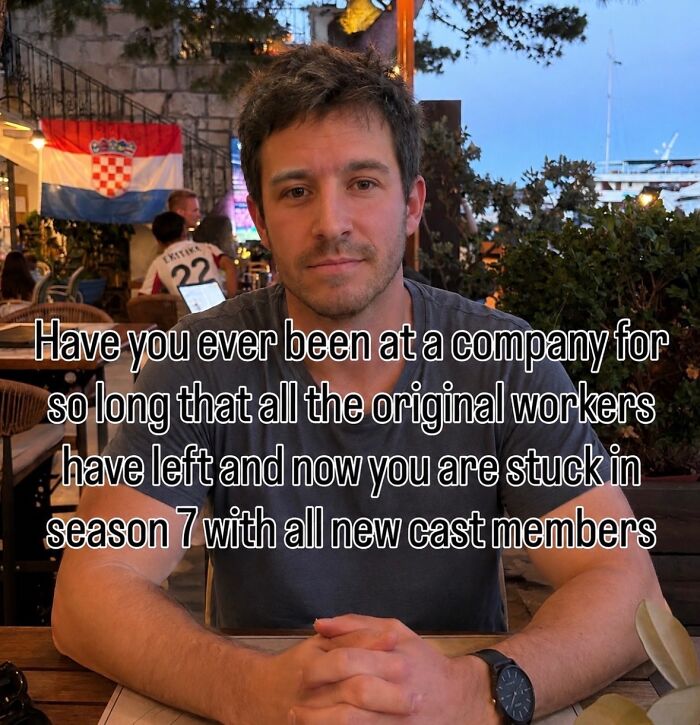 A relatable meme of a man with text about feeling stuck in a company like a long-running TV show with new cast members.
