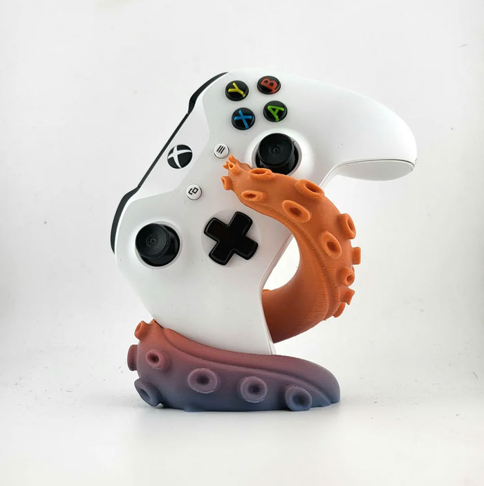 An Xbox controller resting on a 3D printed octopus tentacle stand, an example of cool and useful things people printed with their 3D printers.