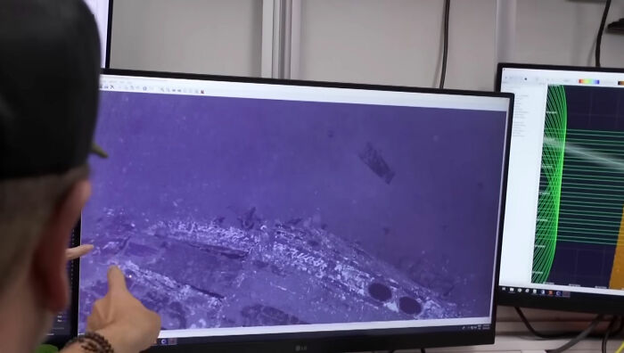 A person pointing at a computer screen showing underwater wreckage of the Pan Am plane that crashed in 1952, found after 74 years. A person pointing at a computer screen showing underwater wreckage of the Pan Am plane that crashed in 1952, found after 74 years.