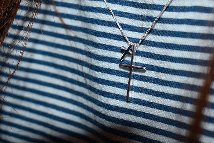Two cross necklaces, symbolizing how names often reflect a child's unfortunate parentage.