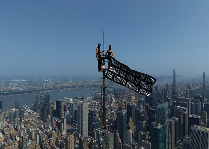 Two daredevils on top of the Empire State Building with a banner, related to the Empire State Building daredevil case.