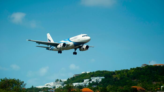 Airplane landing over a hill with houses, representing scenarios that could lead to life-changing accidents.