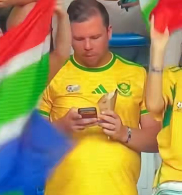 A man distracted by his phone during a World Cup moment, part of a viral backfire for the couple. A man distracted by his phone during a World Cup moment, part of a viral backfire for the couple.